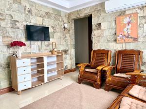 a living room with two chairs and a tv at Serenity Home - 4 bedroom home in Iloilo City