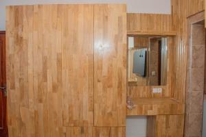 a bathroom with a wooden wall with a tv on it at RAWADE Guesthouse in Cotonou