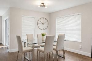 a dining room with a glass table and chairs and a clock at Jackson Pines Getaway in Jackson