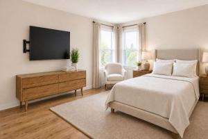 a bedroom with a bed and a flat screen tv at Jackson Pines Getaway in Jackson +4 photos