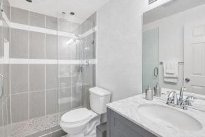 a white bathroom with a toilet and a sink at Jackson Pines Getaway in Jackson