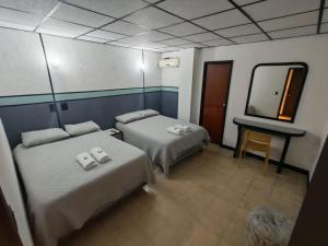 a hotel room with two beds and a mirror at El santa lucia in Panama City