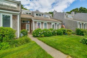 a house with a grass yard in front of it at Riverside Extended Stay in Mashpee in Mashpee