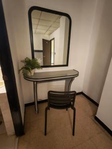 a table with a mirror and a chair in a room at El santa lucia in Panama City +1 photo