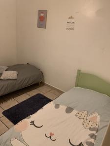 a bedroom with two beds and a rug on the floor at Le Jocondien in Joué-lès-Tours