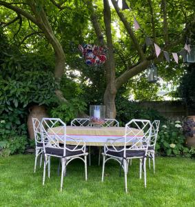 a table and chairs in the grass under a tree at St Columbas Boutique BnB in Weobley