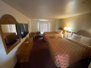 a hotel room with two beds and a television at Sunshine inn in Centre