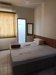 a bedroom with a large bed and a window at Ubaense Suites in Ubá