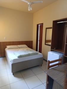 a bedroom with a bed and a ceiling fan at Ubaense Suites in Ubá