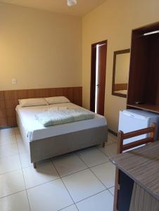 a bedroom with a bed and a mirror in it at Ubaense Suites in Ubá