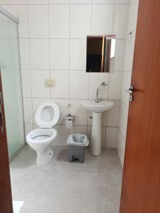 a bathroom with a toilet and a sink at Ubaense Suites in Ubá