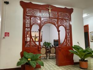 a large wooden door in a room with chairs at Hotel Los Ángeles in Buga