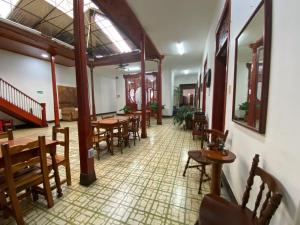 a restaurant with wooden tables and chairs in a room at Hotel Los Ángeles in Buga