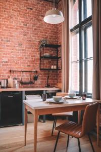 a kitchen with a table and a brick wall at Old Post Loft Apartments in Spremberg +18 photos
