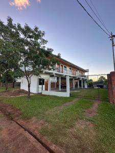 a white building with a tree in front of it at Vivíana Hause Hospedaje in Cambyretá