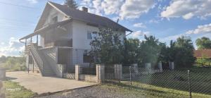 a white house with a fence in front of it at Apartman T&N in Šušnjari