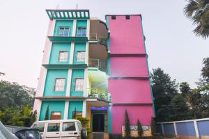 a colorful building with a white van parked in front of it at Hotel O Aagman Guest House in Hākala