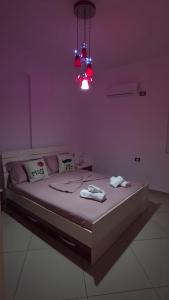 a bedroom with a bed with a purple wall at Luxury Apartment Krisi Sarandë in Sarandë