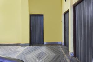 two doors in a room with a wooden floor at Hotel O Aagman Guest House in Hākala +33 photos