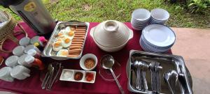 a table with food and plates and a hat on it at สะปันฮิลล์ Sapan Hill in Ban Huai Ti