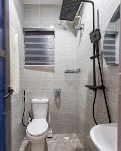 ein Badezimmer mit Toilette und Dusche mit Kamera in der Unterkunft ICH Haven in Ibadan
