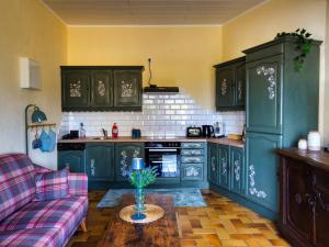 a kitchen with green cabinets and a couch and a table at Ferienwohnung Dreamy Daisy in Morbach