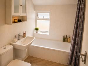 a bathroom with a tub and a sink and a toilet at Amethyst Loft Room in Farnham Royal