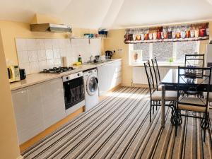 a kitchen with a table and a washing machine at Amethyst Loft Room in Farnham Royal