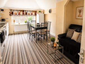a living room with a table and a couch at Amethyst Loft Room in Farnham Royal