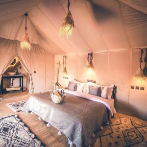 a bedroom with a bed in a tent at Sahara Nights Luxury Camp in Merzouga