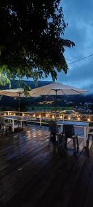 a group of benches with an umbrella on a deck at สะปันฮิลล์ Sapan Hill in Ban Huai Ti