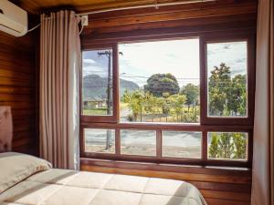 a bedroom with a large window with a view at Hotel pousada BR 285 in Turvo