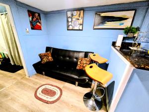 a living room with a black couch and a yellow chair at 2 BEDROOM APARTMENT 20 min-Newark Airport 15 min- Stadium Downtown Newark- Branch Brook park inn in Newark