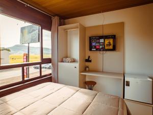 a bedroom with a bed and a large window at Hotel pousada BR 285 in Turvo