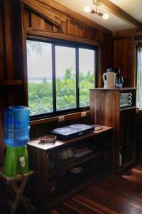 a kitchen with a large window and a table at Cabinas Jenny Cahuita in Cahuita