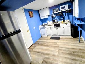 a kitchen with blue walls and a stainless steel refrigerator at 2 BEDROOM APARTMENT 20 min-Newark Airport 15 min- Stadium Downtown Newark- Branch Brook park inn in Newark