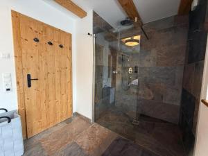 a bathroom with a shower with a wooden door at Wildrose in Wagrain +34 photos