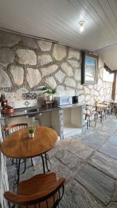 a room with a table and chairs and a stone wall at Pousada Mineira in Ouro Preto