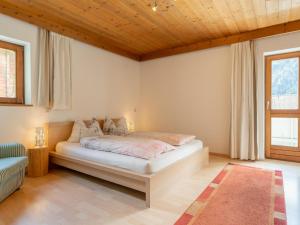 a bedroom with a bed with a wooden ceiling at Tauernpanorama in Krimml