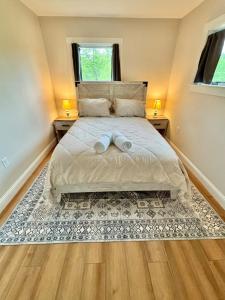 a bedroom with a large bed with two towels on it at The Happy Hive in Bridgton