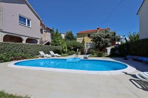a swimming pool with a fountain in a yard at Family-friendly apartments with swimming pool Banjol, Rab - 5007 in Rab