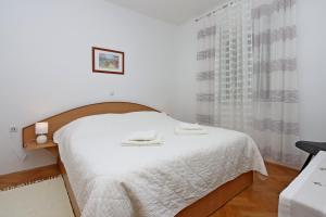 a bedroom with a bed with two towels on it at Family-friendly apartments with swimming pool Banjol, Rab - 5007 in Rab +23 photos