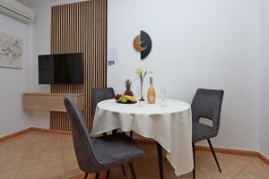a dining room with a table and chairs and a television at Family-friendly apartments with swimming pool Banjol, Rab - 5007 in Rab