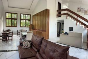 a living room with a leather couch and a table at Hotel pousada BR 285 in Turvo