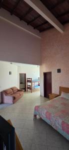 a room with two beds and a couch and a television at Pousada Peruibe in Peruíbe