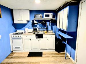 a kitchen with blue walls and white cabinets at 2 BEDROOM APARTMENT 20 min-Newark Airport 15 min- Stadium Downtown Newark- Branch Brook park inn in Newark +17 photos