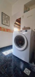 a washing machine in a room with a tile floor at Cabaña con balcón luminosa in Ushuaia