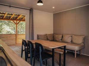 a living room with a couch and a table and chairs at Timber-Lodge in Vessem