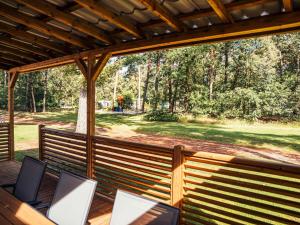 a screened porch with chairs and a view of a yard at Timber-Lodge in Vessem