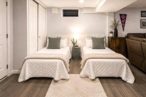 two beds in a living room with a couch at Saddle Brook Studio with Patio - Near NYC! in Saddle Brook